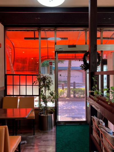 店内から見たオレンジのテントと窓の外の風景