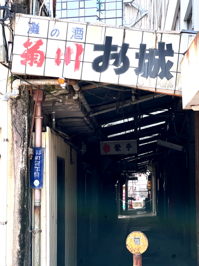 灘の酒 菊川 お城と書かれた手書き風の古いアクリル看板が架かる薄暗いお城街の通路
