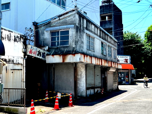 ビルの一角から突き出すように建てられたトタン屋根と古びた居酒屋が並ぶお城街の入り口