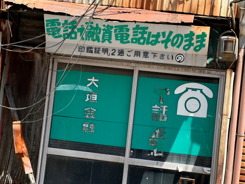 昭和の黒電話のイラストがレトロに描かれた、大垣金融の古い融資広告看板