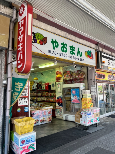やおまんと書かれた果物店の店頭に並ぶ立派な手編みの山盛りの籠もり