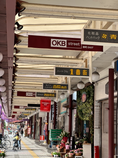 青空の下に広がる大垣駅前商店街（OKBストリート）の広々とした片側2車線道路とアーケードの全景