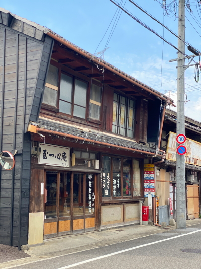 花村製油所の店舗入り口横に貼られた、豊年天ぷら油と書かれた昭和レトロな赤いホーロー看板