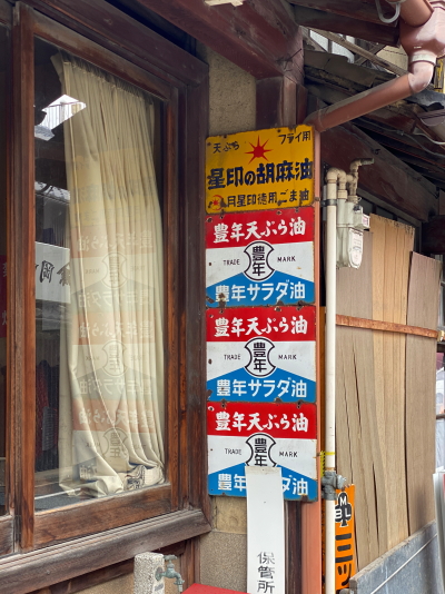 花村製油所の外壁に架かる、TRADE MARKの英字ロゴと商標が描かれた豊年天ぷら油のレトロな鉄看板