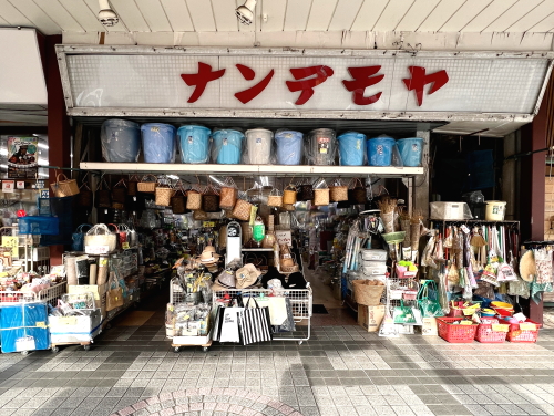 ナンデモヤと書かれた看板と店頭に所狭しと並ぶ昭和レトロな雑貨や玩具の数々