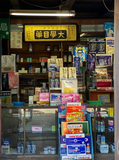 ガラス越しに見える水野薬局店内の大學目藥の金文字額