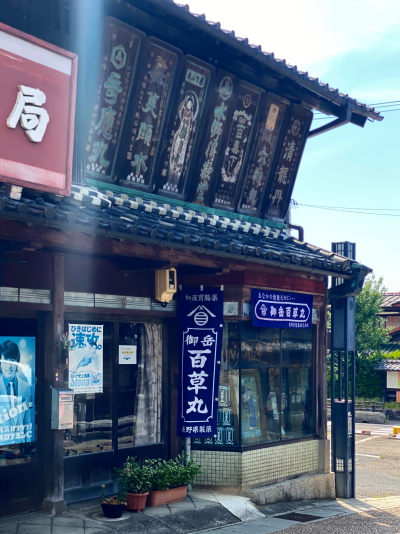 美顔水や奇応丸などの文字が刻まれた水野薬局の巨大な木彫り金看板