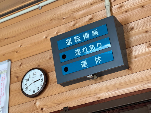 遅れあり・運休などの文字が入った木枠の手動式案内表示板