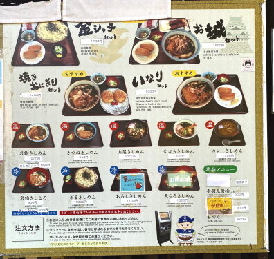 「金シャチセット 1700円」「お城セット 1600円」や「名物きしめん 900円」「名物きしころ 900円」など、豊富なセットや単品麺類の価格と写真が掲載された店頭の大きなメニュー看板。