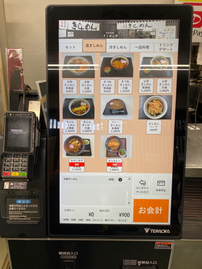 日本語と英語に対応し、タッチパネルと多言語選択が可能な比較的新しい券売機。クレジットカード対応のロゴも掲示され、キャッシュレスでもスムーズに食券を購入できます。