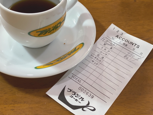 ロゴ入りオリジナルカップに入った自家焙煎ブレンドコーヒーと伝票