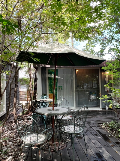 cafeけやきの杜の奥に広がる緑豊かなテラス席と敷地内の風景