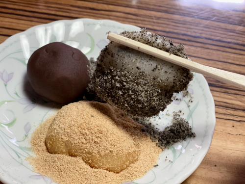 箸で持ち上げた柔らかい黒ごまのかんから餅
